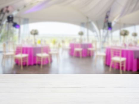 White wooden empty table in front of blurred restaurant interior background. Perspective white wood board over blur in restaurant or cafe - mockup for display or montage your products