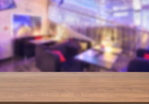 Dark wooden board empty table in front of blurred background. Perspective brown wood over blur in cafe interior - can be used for display or montage our products. Mockup your products