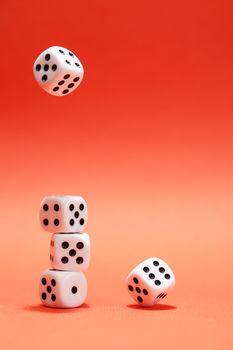 Dice game. One dice cube falling to another dices on red background