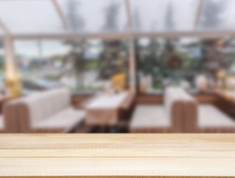 Wooden board empty table in front of blurred background. Perspective light wood over blur in cafe interior - can be used for display or montage your products. Mockup your products