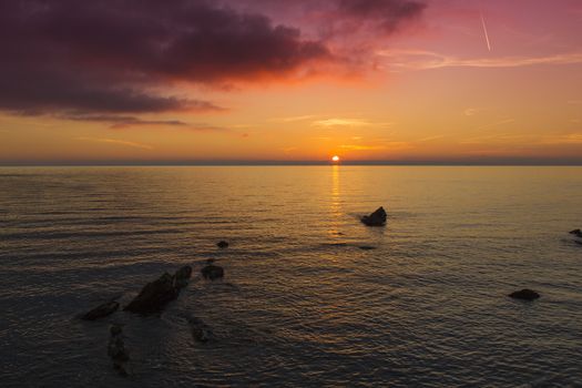 Sea panoramic view of the sun setting with purple sky