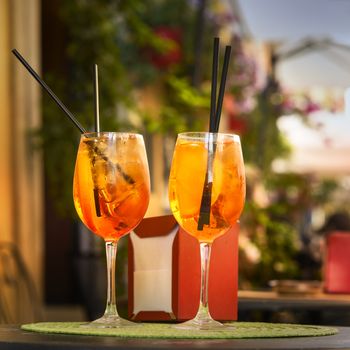 Aperol Spritz Cocktail. Alcoholic beverage based on table with ice cubes and oranges.