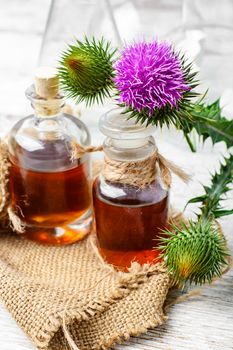 Flowering buds plant Thistle, and a small bottle of medicinal tincture