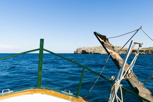 View of the coast of the island of Rhodes by the bow of a boat