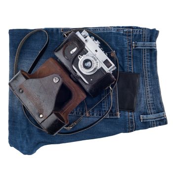Blue jeans and an old camera isolated on white background.