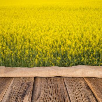 empty wooden planks with blurred background blooming yellow rape flowers