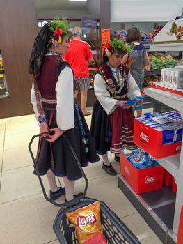 KAZANLAK, BULGARIA - JUNE 05, 2016: Women in national dress are shopping in the supermarket. After the Rose Festival.