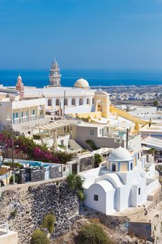 Cityscape of Fira, dramatically located on the edge of the caldera cliff on the island of Thira known as Santorini, Greece. Panorama shot.