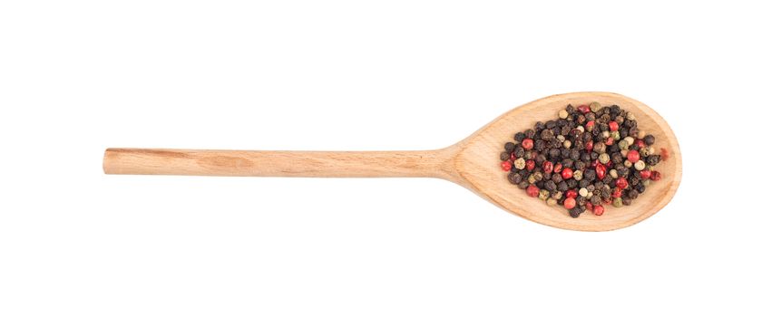 Colored pepper on a wooden spoon isolated on white