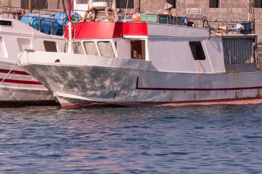 Some colorful fishing boats are anchored in the harbor of Acireale, Sicily-Italy on the coast of the Mediterranean Sea.