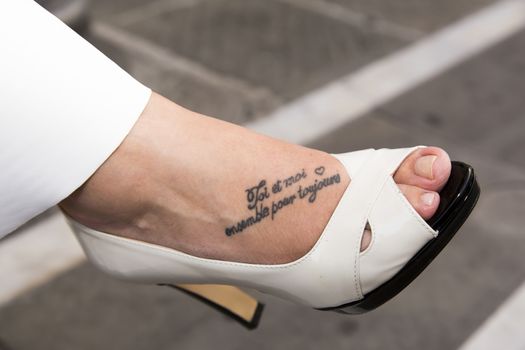 Close-up view of the foot of the bride with tattoo