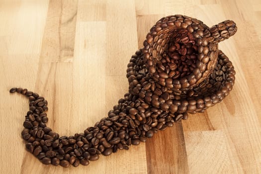 Close up view of a cup covered with coffee beans on a wooden surface