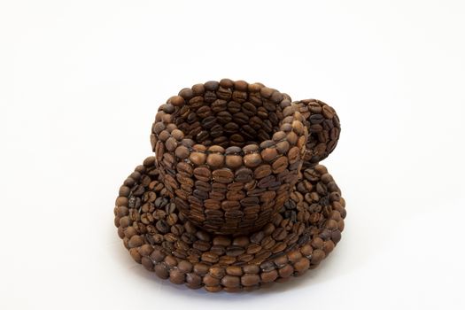 Close up view of a cup covered with coffee beans and white background