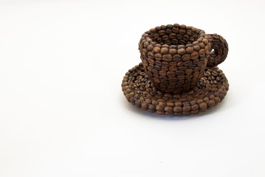 Close up view of a cup covered with coffee beans and white background