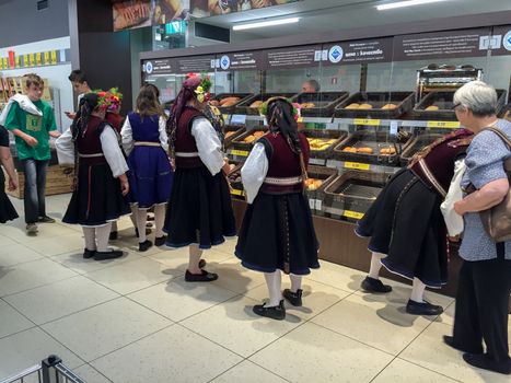 KAZANLAK, BULGARIA - JUNE 05, 2016: Women in national dress are buying bread. After the Rose Festival