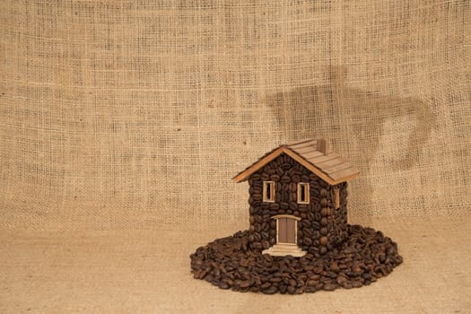 House made of coffee and background screening of shadow of a coffee machine