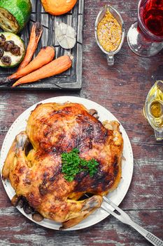 Chicken cooked in vegetables on vintage wooden surface
