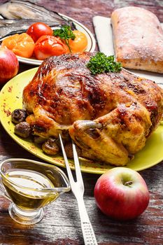 Baked apples chicken with vegetable garnish on wooden background
