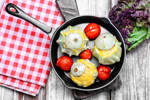 Vegetarian meal of baked squash with tomatoes on frying pan