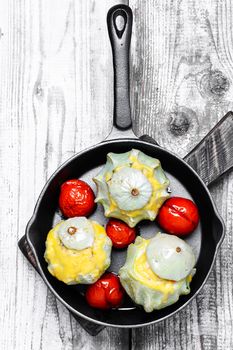 Vegetarian meal of baked squash with tomatoes on frying pan