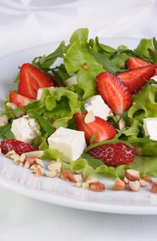 Salad of lettuce, arugula, strawberries, feta cheese and peanuts