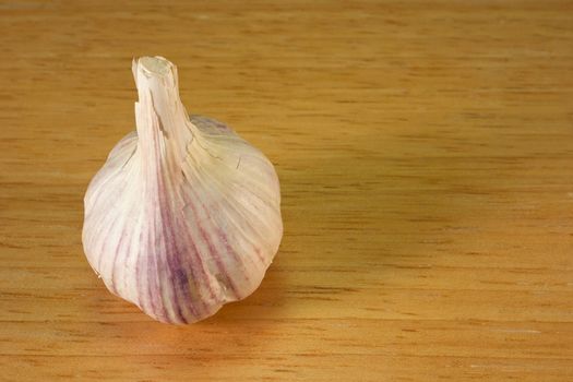 Garlic cloves on a brown breadboard