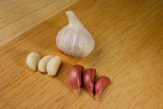 Garlic cloves on a brown breadboard