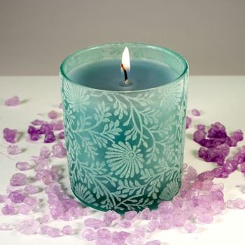 Green candle with purple aromatic sea salt