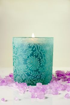 Green candle with purple aromatic sea salt