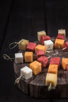 many kinds of cheeses on wooden end of a tree