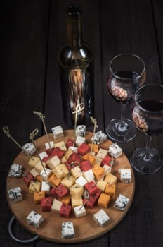 many kinds of cheeses on wooden end of a tree with reed wine