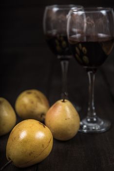 yellow pear with red wine on wooden table