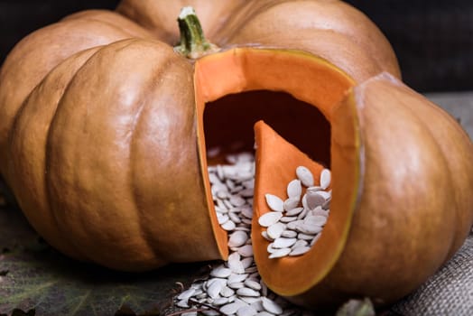 pumpkin lying on a wooden table with viburnum and seeds