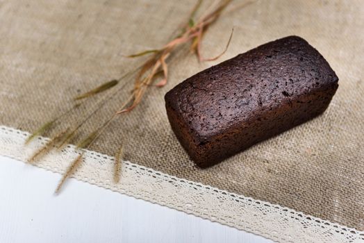 black bread on burlap with ears on a white board