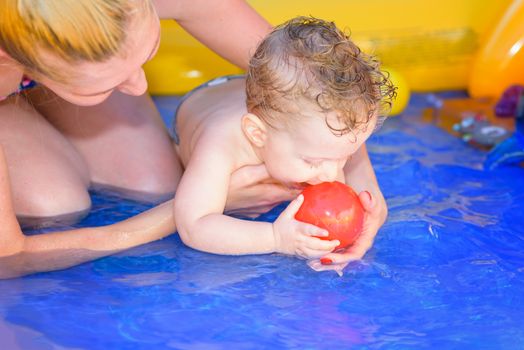 Mother and son play in a small wading pool