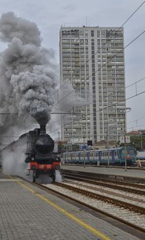Steam locomotive leaving the station in clouds of smoke