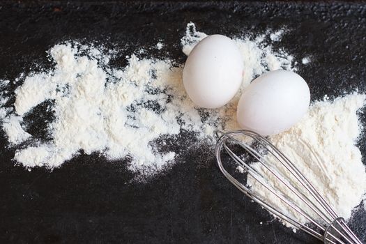 Ingredients for a cake on a black natural stone