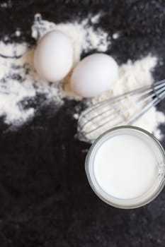 Ingredients for a cake on a black natural stone