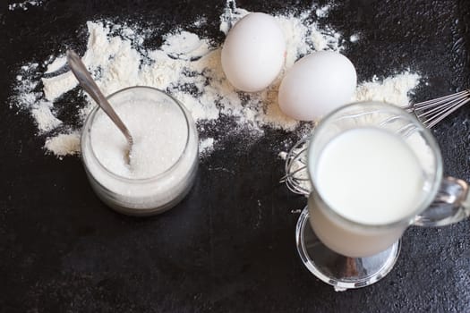 Ingredients for a cake on a black natural stone