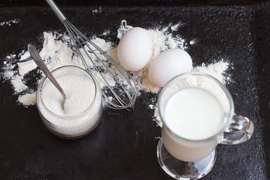 Ingredients for a cake on a black natural stone