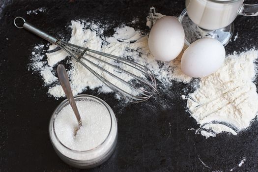 Ingredients for a cake on a black natural stone