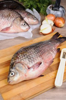 Fresh crucian carp lying on a cutting board for cutting cooked