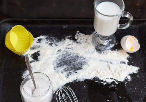 Ingredients for a cake on a black natural stone