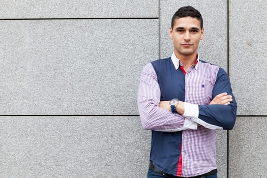 Portrait of a young man half french and half arabic happy with arms crossed