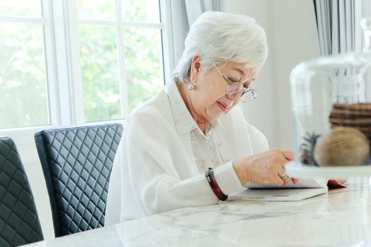 Senior woman reading a book at home