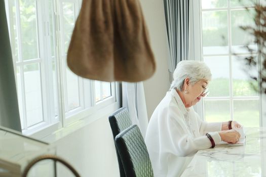 Senior woman reading a book at home