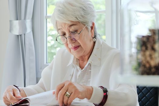 Senior woman reading a book at home