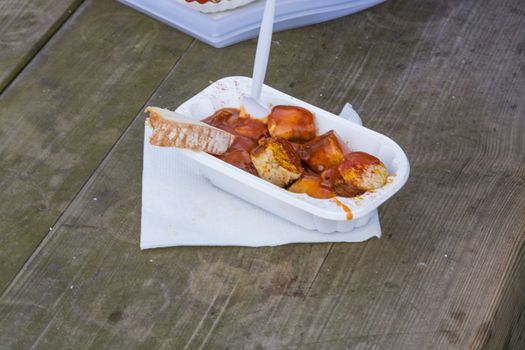 A paper bag with sausage on an old wooden table.
