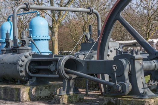 Old industrial sewing machine, water turbine on a concrete base.