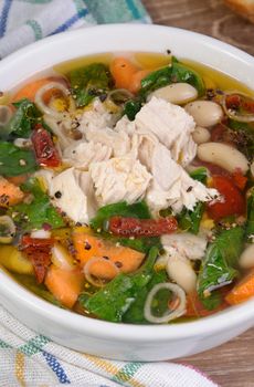 chicken soup with beans, spinach, tomatoes and other vegetables